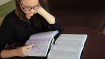woman journaling and an open Bible 