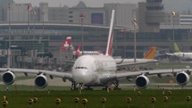 Slow motion video of an Emirates airlines commercial airline moving down a taxiway.