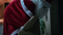 Santa Claus picking presents from his bag in the night 