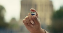 Young woman smiling with an ‘I Voted’ stickers and pin 