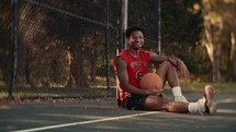 Portrait of a smiling young man playing basketball on a sunny day