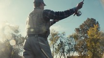 Young fly fisherman casting on a river on a fall morning