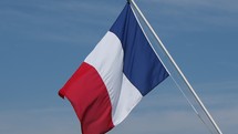the French national flag of France, Europe floating in the wind over blue sky