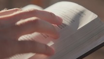 Macro shot of hands studying scripture and holding the Bible 