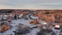 Winter Aerial Serenity: Drone Flight over a road with houses below