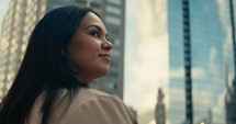 Young woman admiring downtown city buildings and scenery during sunset