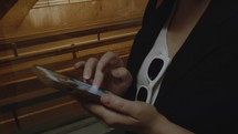 Close-up - hands of a woman holding a smartphone in a dark space