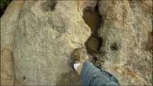 Hiking POV over a granite slab with pools of water