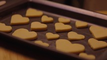 Heart shaped cookies being moved on a tray for Valentine's Day