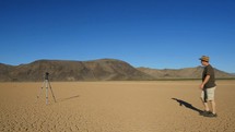 A man taking a photograph in a barren desert location