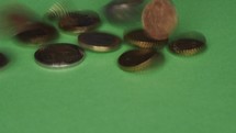euro coins falling over a green background