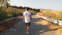 Man Walking And Following The Road In The Nature