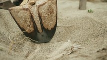 close up of shovel digging into the sand.