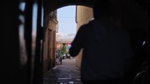 people walk through a narrow alley in an old town