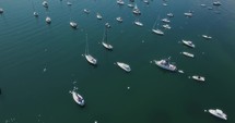 Drone flies over sailboats in a bay, top shot