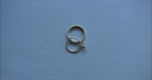 Gold wedding rings of bride and groom, husband and wife together by window light on wedding day.