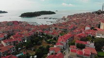 drone flies over medieval town on the coast with church