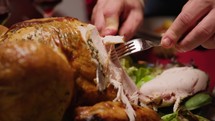 Man cutting roasted Chicken with knife for thanksgiving day in home