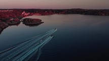 drone flies over Swedish archipelago at sunset in skarhamn with water skis