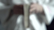 a person in a bathrobe holding a Bible 