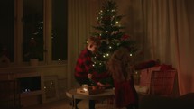 Children Reading the Bible by the Christmas Tree