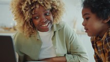 African American Kid Discussing Something on Laptop Screen with Mom at Home
