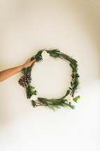 hand holding a Christmas wreath 