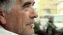 Close up of a gray haired man looking away from camera.