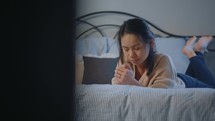 teen girl praying in her bedroom 
