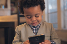 toddler boy holding a cellphone 