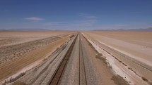 Aerial of railroad tracks running through a desolate desert