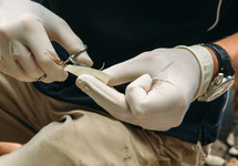 a doctor threading a needle for stitches 