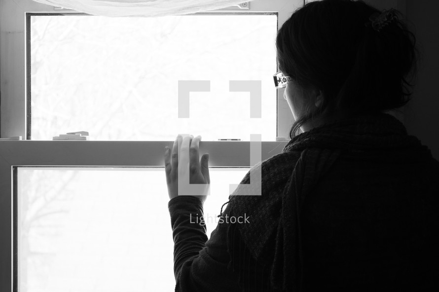 a woman looking out a window 