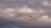 Plane flying in slow motion against a cloudy sky