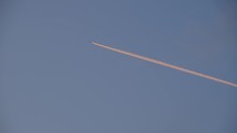 A long contrail from an airplane in the blue sky