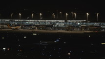 Commercial airplane moving on the airport taxiway at night.