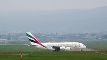 Emirates airlines commercial airplane about to take off a runway.