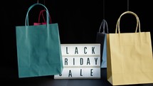 Shopping bags floating around Black Friday sign