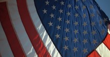 Closeup of American, USA flag blowing in the wind in slow motion on fourth of July, Independence Day.