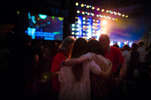 hugs during a Christian music concert 