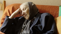 Elderly woman with her eyes closed.