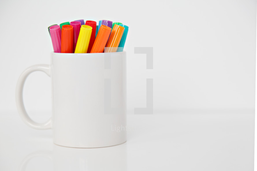 markers in a white mug 