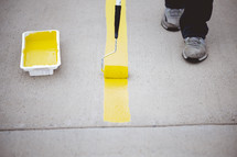 painting yellow stripes in a parking lot 