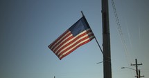 USA, United States American flag flying, blowing in wind on 4th of July in slow motion.