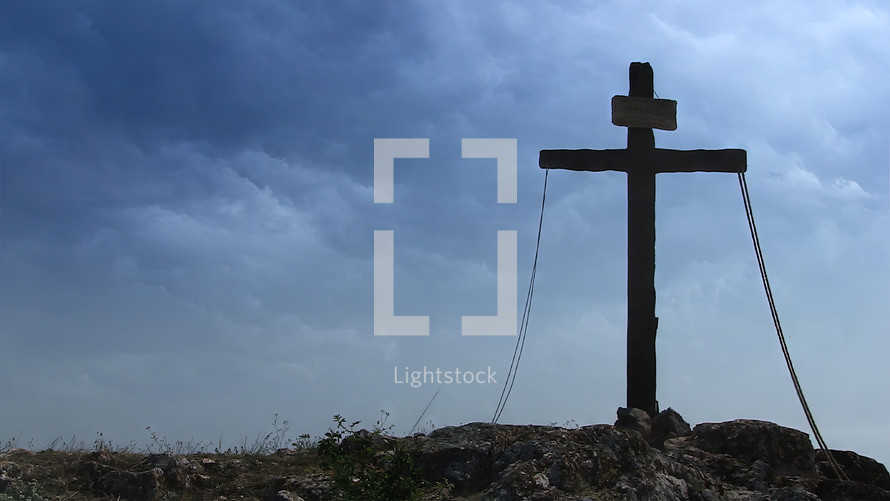 Wooden cross on a stormy day representing Sacrifice of Jesus Christ from Calvary hill, outside ancient Jerusalem.
