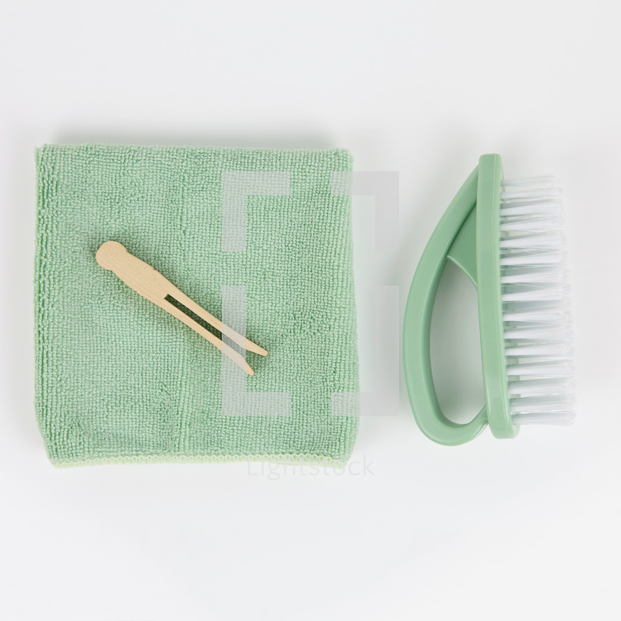 vintage clothespins, mint towel, and brush on white background 