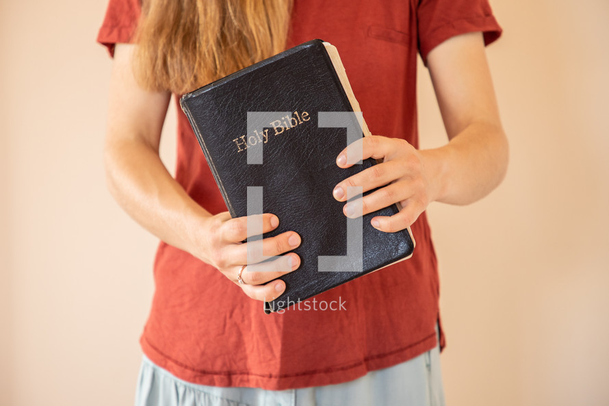a girl holding a Holy Bible 