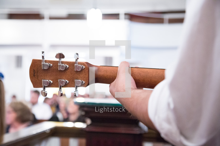 man playing a guitar during a worship service 