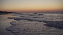 tide washing onto a shore a sunrise 