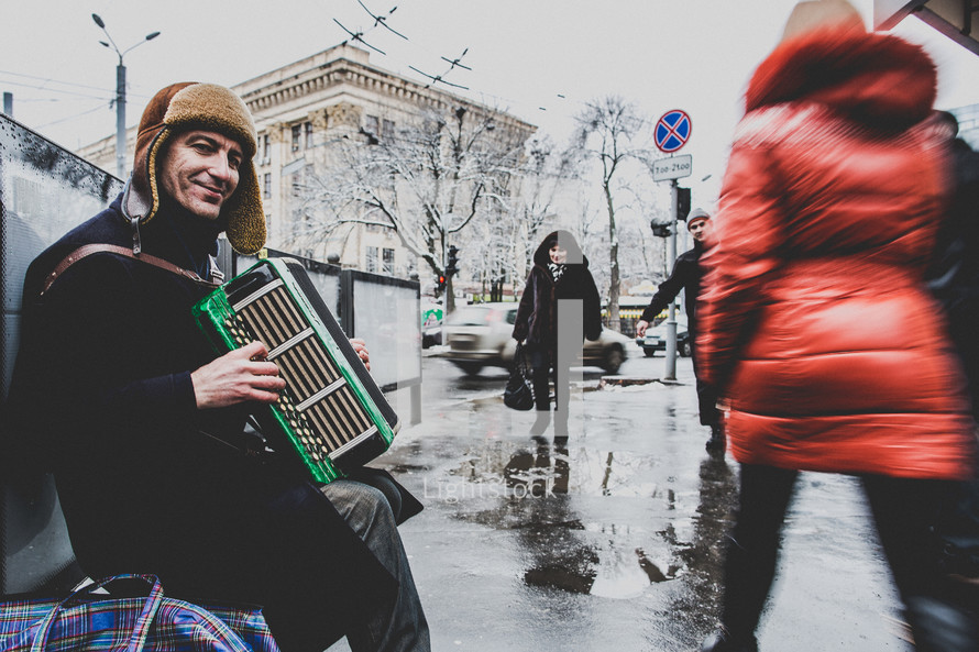 man sitting on a bench playing an accordion